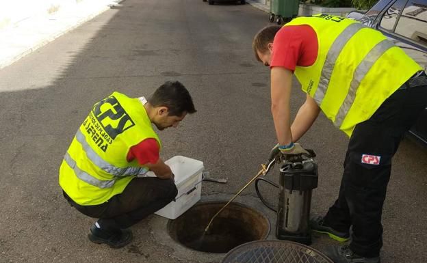 Operarios desratizando una alcantarilla